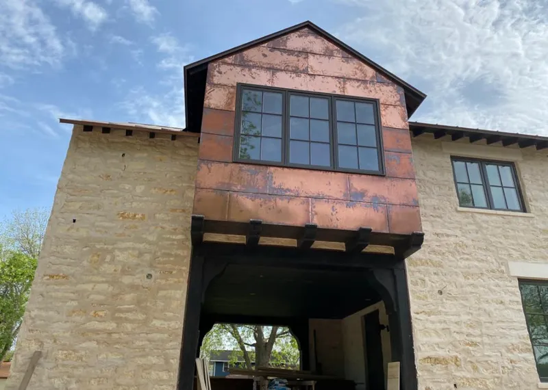 Copper metal panel facade on a stone building for Skylight Installation in Thomaston